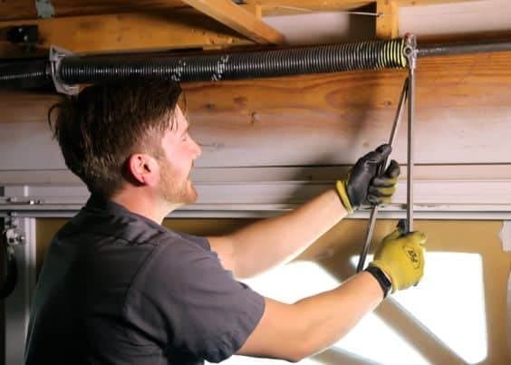 Garage door technician inspecting hardware
